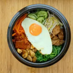 Kolorowe bibimbap, klasyczne danie kuchni koreańskiej, z jajkiem sadzonym, warzywami i mięsem.