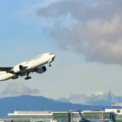 Samolot Air France wznosi się nad lotniskiem, a w tle widać ośnieżone góry. Idealny widok dla tych, którzy zastanawiają się, jak szukać lotów czarterowych.