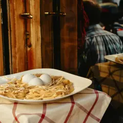 Świeży makaron i jajka na talerzu, zapowiedź autentycznej kuchni włoskiej.