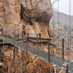 Spacer po Caminito del Rey z dzieckiem. Wąska ścieżka zawieszona nad przepaścią, otoczona skalnymi ścianami.