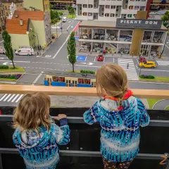 Dwie dziewczynki podziwiają miniaturowe miasto, gdzie znajdują się sky tower atrakcje dla dzieci.