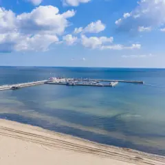 Molo z jachtami i żaglówkami, idealne miejsce na atrakcje dla dzieci nad morzem. Piękny, słoneczny dzień.