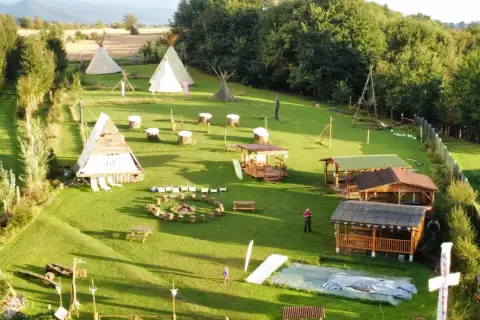 Wioska indiańska w Lubelskiem z tipi, drewnianymi chatkami i miejscem na ognisko.