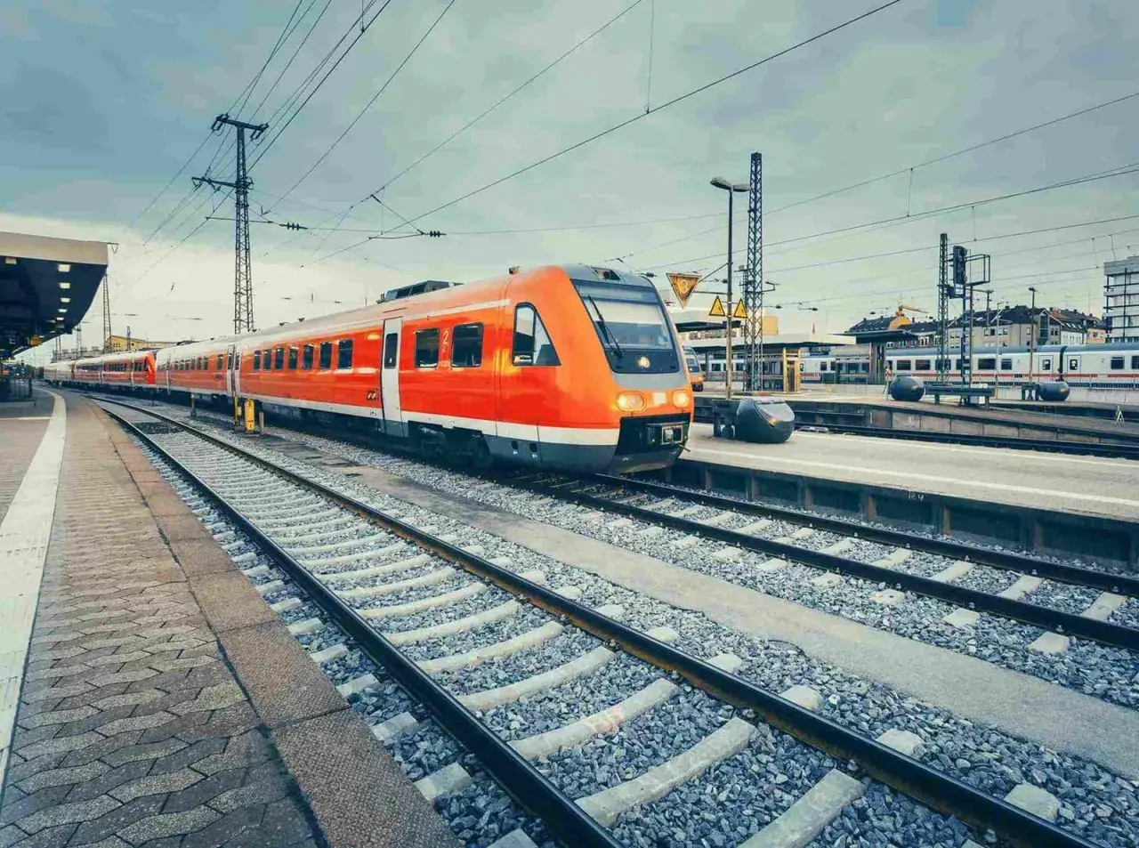 Pomarańczowy pociąg na stacji, gotowy do podróży. Jastarnia Hel odległość to tylko kilka godzin pociągiem.
