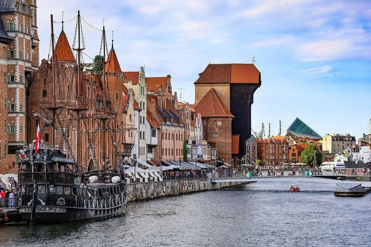 Gdańsk z pirackim żaglowcem i Żurawiem, jakby z Władysławowa przybył. W tle most i nowoczesna architektura.