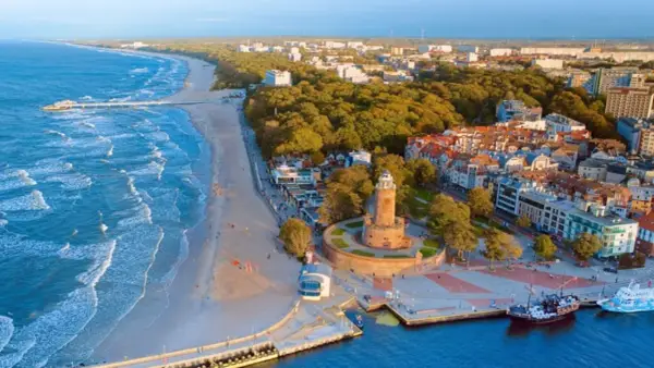 Malownicze miejscowości nad morzem z latarnią morską, plażą i portem.